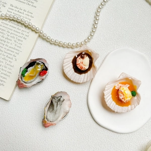 Macro shot of realistic resin oyster and scallop food models on a marble surface