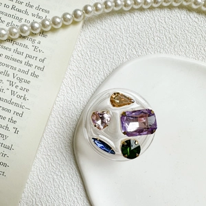 Detail of a round collapsible phone grip with colorful rhinestones and retro crystal gems