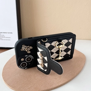 Detail of iPhone case with black and white diamond pattern wallet and gold horsebit