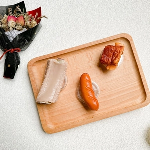 Close-up of realistic food-shaped phone grips including ribs and sausage on wooden tray