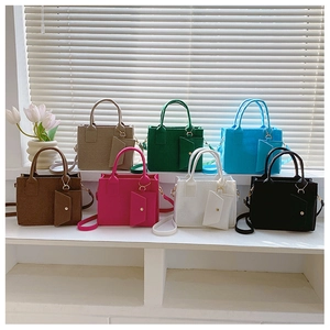 Collection de sacs à main gaufrés en sept couleurs avec breloques sur un rebord de fenêtre