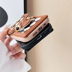 Detail of luxury quilted iPhone case with golden horsebit and black silicone cover