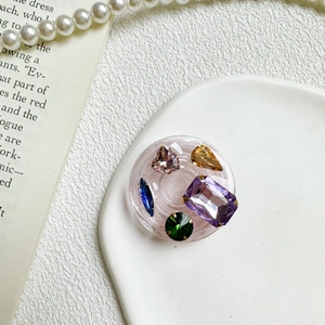 Detail of pink resin phone grip featuring multi-color rhinestones and crystal gemstone inlay