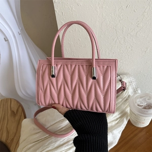 Pink quilted faux leather handbag with round top handles and detachable shoulder strap