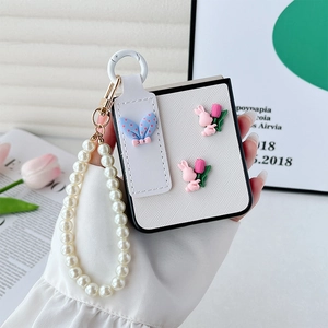 Close-up of white leather Z Flip case with pearl wrist strap, pink bunny and tulip charms