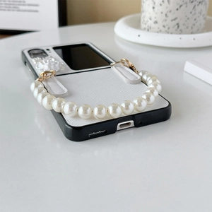 Close-up of foldable phone case featuring elegant white pearls and 3D floral accents