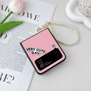 Detail of pink woven texture phone case for Samsung Z Flip with pearl wrist strap and tulips
