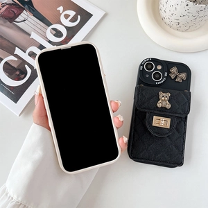 Detail of black quilted iPhone case featuring metal bear charm and a functional card holder