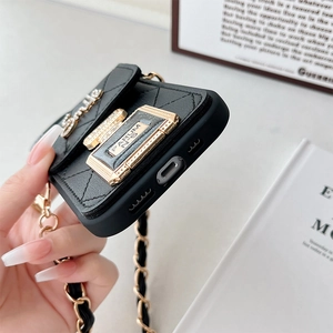 Détail de la coque iPhone en cuir matelassé noir avec lettrage Smile et breloque parfum