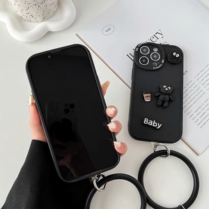 Detail of matte black iPhone case featuring a 3D cartoon bear and silicone wrist strap