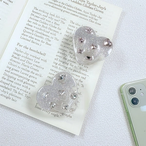 Detail eines glitzernden Herz-Handyhalters mit rosa Strasssteinen und Kristallen