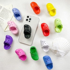 Dettaglio ravvicinato di mini supporti per telefono a forma di ciabatta in vari colori