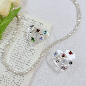 Close-up of heart-shaped phone grips with colorful rhinestones and gold Diamonds text