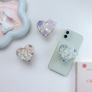 Close-up of heart-shaped phone sockets with pearls, crystals and bows on leather