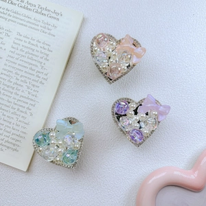 Detailed macro view of heart-shaped phone grips with pearls and colorful bows decoration