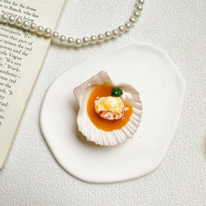 Detailed close-up of a realistic creative scallop seafood phone grip on a white ceramic plate