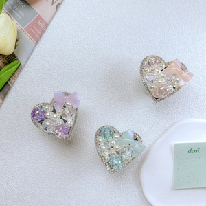 Detail of heart-shaped phone grips with pearls, rhinestones and colorful bows