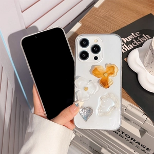 Clear iPhone case with 3D amber floral ornaments, pearls, and glitter hearts decoration