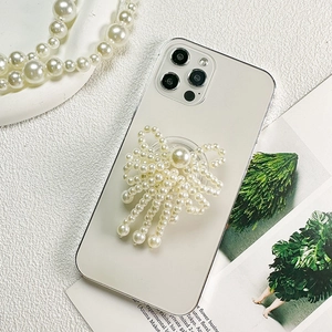 Detail showing elegant white pearl bow phone grip with tassels on a white background