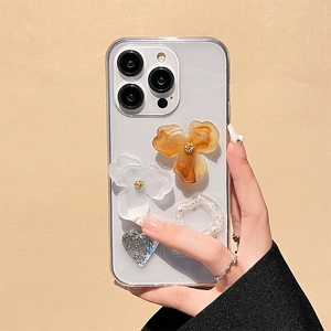 Detail of clear iPhone case featuring resin flowers and pearl ring held by hand
