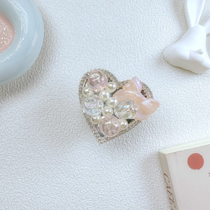 Detail of luxury heart phone grip with pearls, rhinestones, and pink butterfly bow