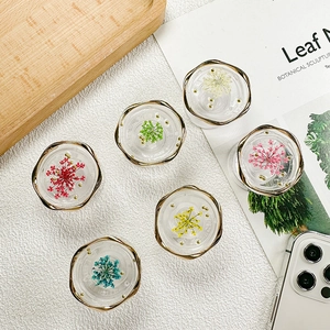 Detailed macro of floral phone griptoks with real dried flowers and gold metal rims