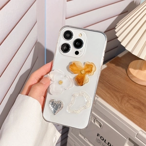 Detail of clear iPhone case with amber flowers, white pearls and silver glitter hearts