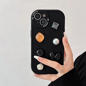 Detail of matte black phone case featuring 3D marble heart, pearl, and floral crystal gems