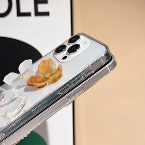 Detail of 3D resin floral ornaments and pearls on clear iPhone case with gold accents