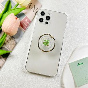 Floral resin phone pop socket with green dried flower and gold wavy metal rim on white phone
