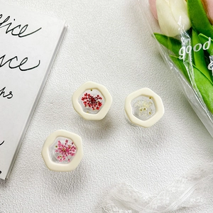 Close-up of hexagonal phone grips featuring real dried flowers in cream frames