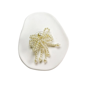Elegant pearl bow expandable phone socket grip with hanging pearl tassels on white tray
