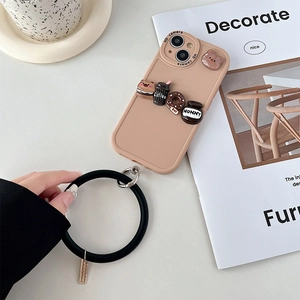 Detail of soft pink silicone phone case featuring 3D bear, donut charms and black wrist strap