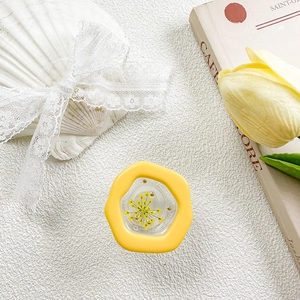 Macro detail of yellow flower griptok with real dried petals and resin finish