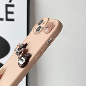 Macro side view of cute peach phone case with 3D bear and donut charms for iPhone