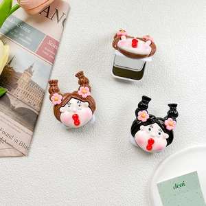 Close-up of cute cartoon doll foldable makeup mirror with decorative floral hair accessories