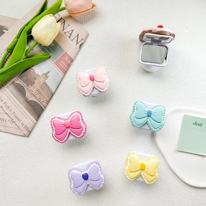 Detailed view of colorful bow-shaped phone grip mirrors with elegant white lace borders