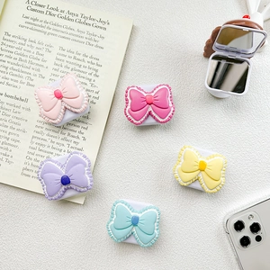 Flat lay of colorful bow-shaped phone grip sockets with lace edges in five pastel colors