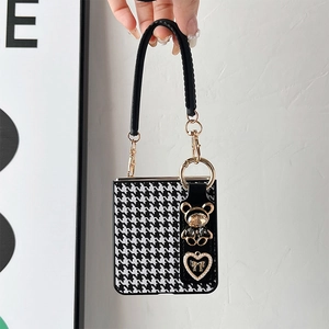 Detail of houndstooth folding phone case with luxury rhinestone bear and pearl charms