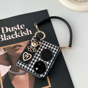 Detail of houndstooth phone case with rhinestone bear and pearl heart handbag strap