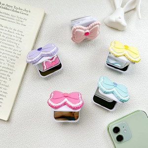 Foldable bow-shaped phone mirror stands in five pastel candy colors on a marble surface