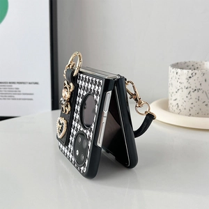 Chic houndstooth folding phone case with leather strap, gold charms, and heart detail