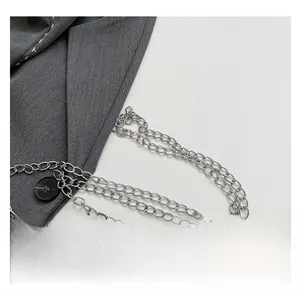 Macro detail of a silver metal chain strap and vintage kiss-lock on a cloud clutch bag