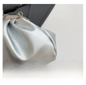 Detail of silver metallic cloud bag with gathered texture and metal chain strap