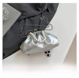 Mini silver cloud clutch bag size comparison with phone showing pearl handle and chain
