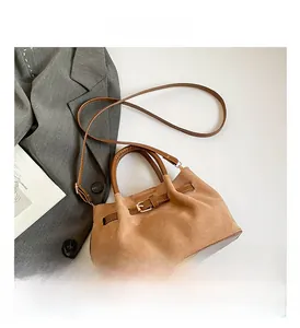 Detailed view of brown suede bucket bag with adjustable strap and buckle closure