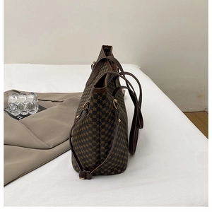 Side view of large retro tote bag featuring brown geometric pattern and leather handles