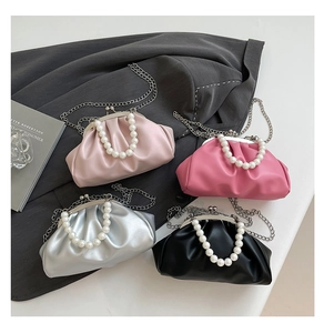 Detail view of four pleated cloud bags in pink, silver, and black with pearl handles