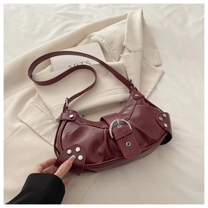 Detailed close-up of burgundy retro pleated handbag with silver buckle and studs