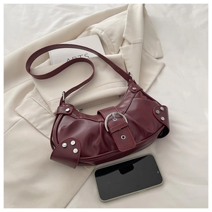 Detail of vintage burgundy pleated shoulder bag with silver buckle and stud accents